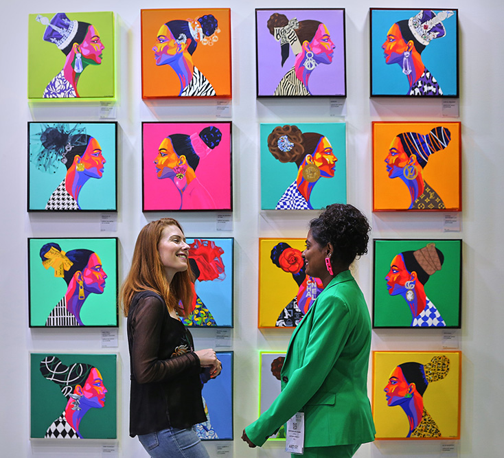 Visitors networking in front of contemporary artwork at World Art Dubai