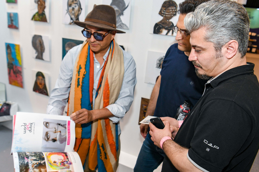 Collectors discussing artwork at a gallery booth during World Art Dubai
