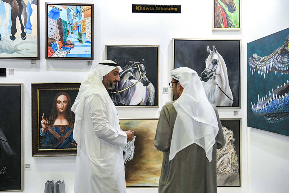 Buyers exploring artwork at a gallery booth during World Art Dubai art fair